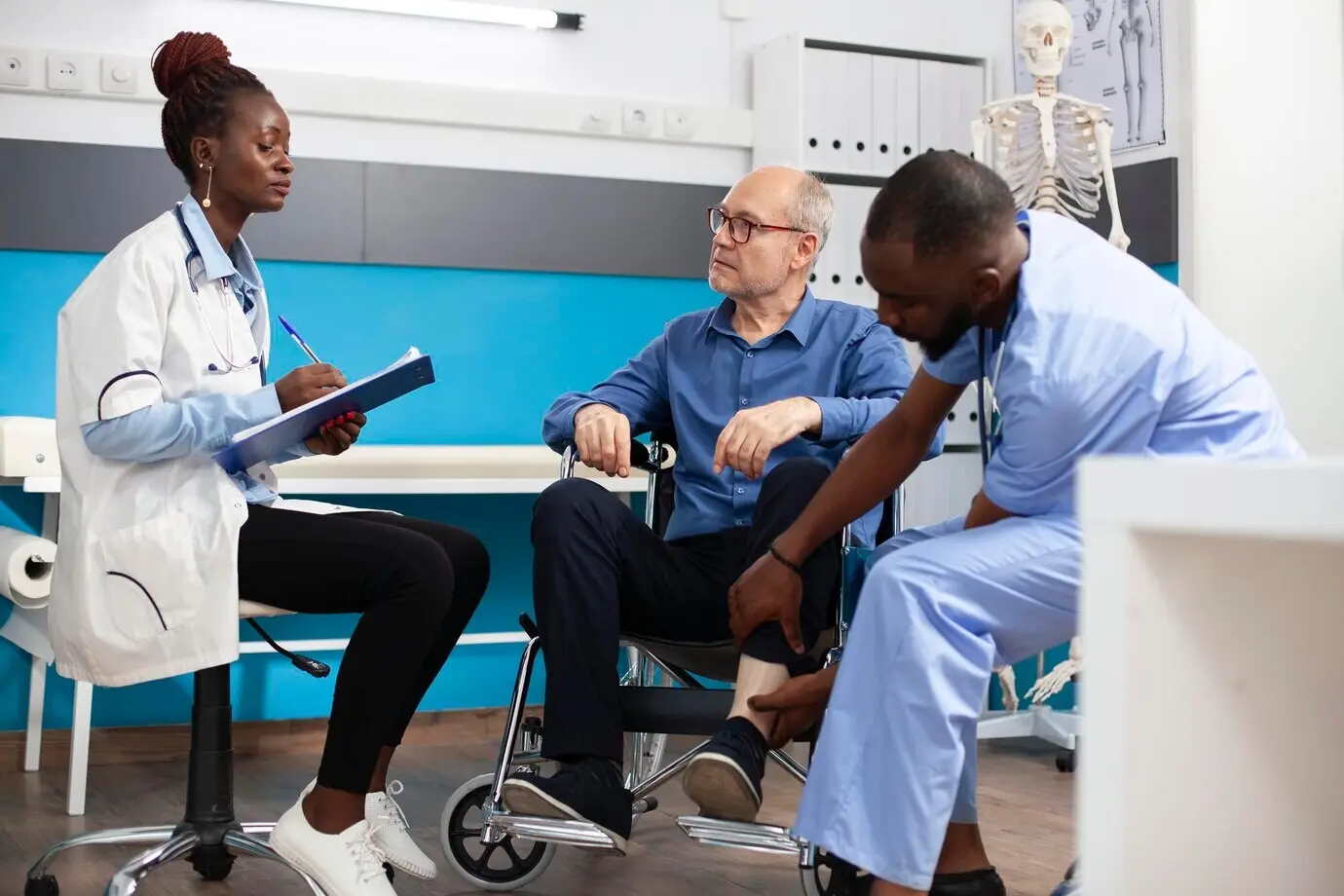 Un médico y una enfermera ayudan a una persona en silla de ruedas.